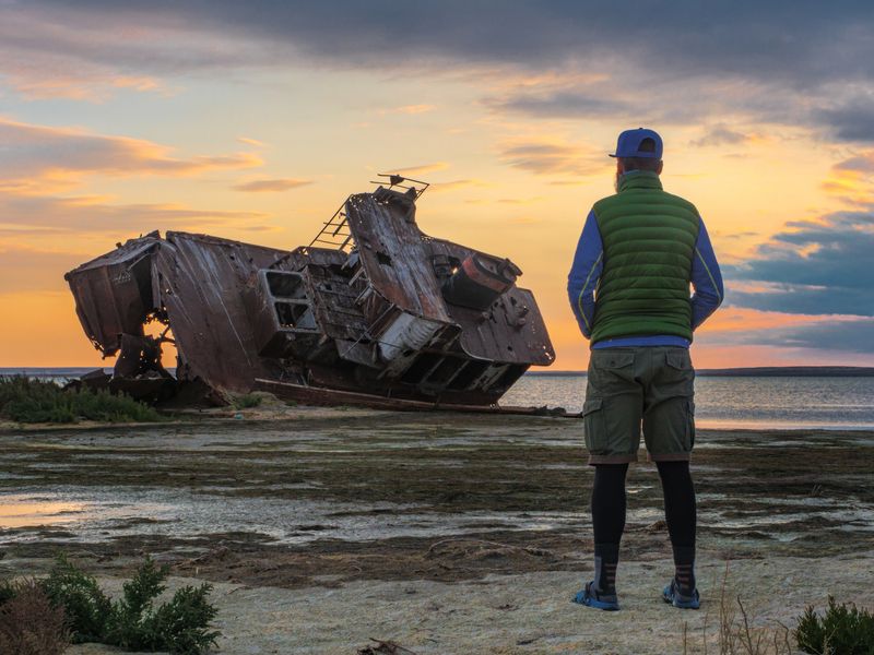 A man stands by an old abandoned ship on the shores of the Aral Sea in Kazakhstan. 