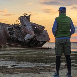 A man stands by an old abandoned ship on the shores of the Aral Sea in Kazakhstan. 
