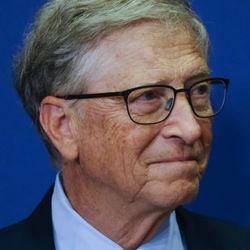 A portrait photo of Bill Gates wearing glasses and a suit and tie
