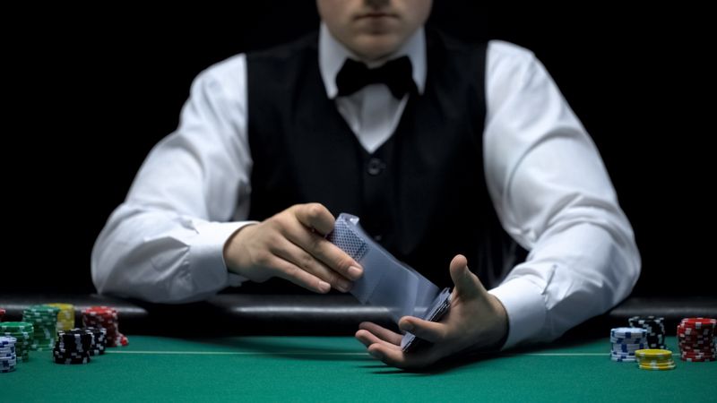 photograph of a croupier shuffling a deck of cards