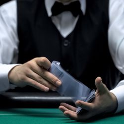 photograph of a croupier shuffling a deck of cards