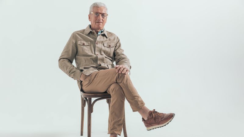 A white-haired man sitting in a chair