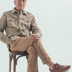 A white-haired man sitting in a chair