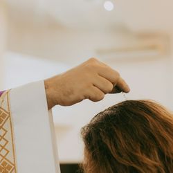 A Christian priest sprinkles water on the head of water in a church