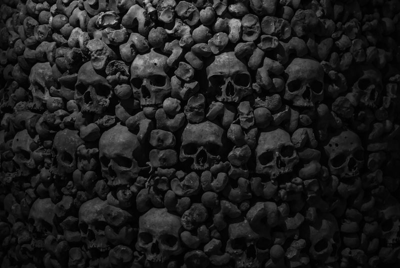 Collection of skulls in dark catacombs