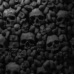 Collection of skulls in dark catacombs