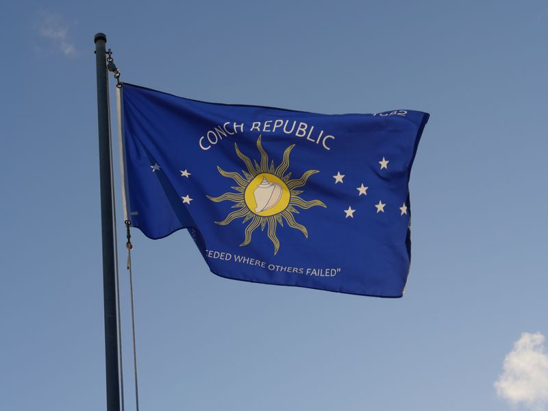 Flag of the Conch Republic (Key West) flying against a blue sky.