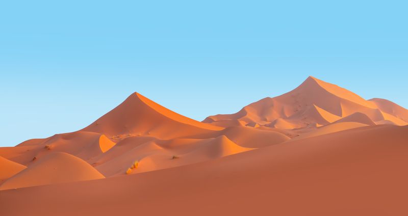 large sand dunes against a blue sky