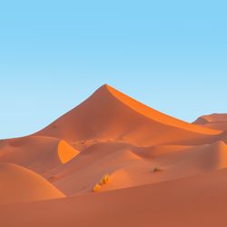 large sand dunes against a blue sky