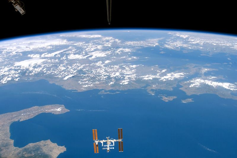 Planet Earth and the International Space Station pictured by an astronaut onboard the Space Shuttle in August 2007