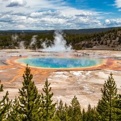 A view of a large blue pond with colorful soil in yellow and orange at its edges