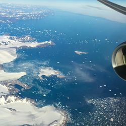 A plane flies over the icy coastline in Sermersooq Municipality, Greenland