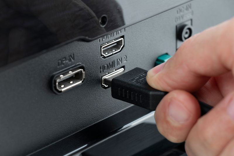 close up of someone plugging in a HDMI cable