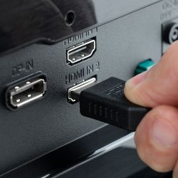 close up of someone plugging in a HDMI cable