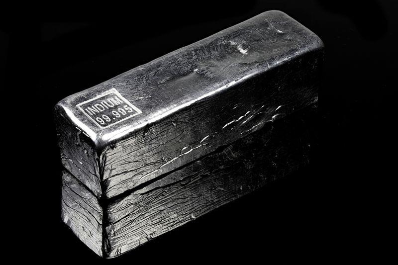 ingot of indium, a silvery white metal, against a black background