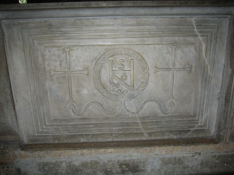 a marble slab with two crosses and a monogram withing a relied of a laurel crown. 