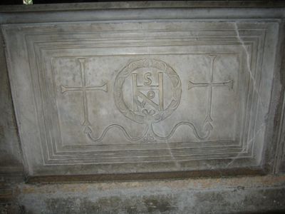 a marble slab with two crosses and a monogram withing a relied of a laurel crown. 