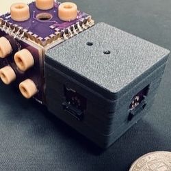 A small rectangular device next to a coin. the divice is 1 coin wide and 3 coins long