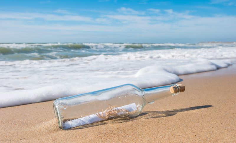 message in a bottle laying on sand