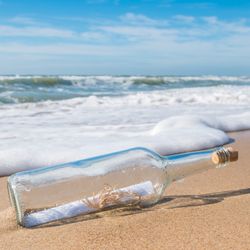 message in a bottle laying on sand