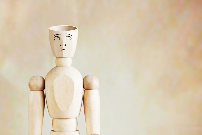 wooden mannequin with empty head and a puzzled face
