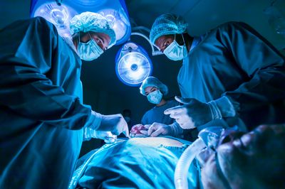 Team of surgeon doctors are performing surgery for a patient in the emergency surgical room