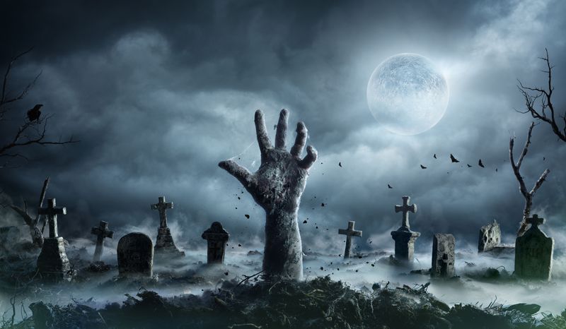 Undead zombie hand rising out of a grave