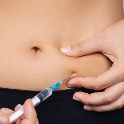 Woman injecting herself in the stomach with a needle