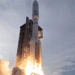 A rocket firing up its engine just moving past the launch tower