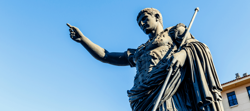 A statue of Julius Caesar, ancient Roman emperor, against a blue sky background.