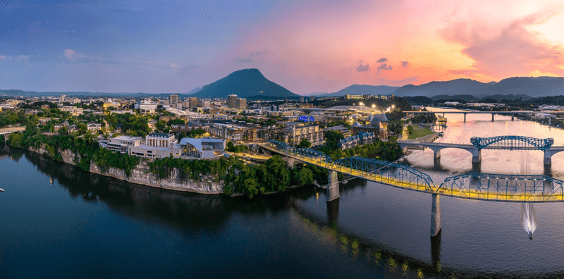 The city of Chattanooga looking nice and picturesque, with river and sunset and bridges.