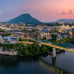 The city of Chattanooga looking nice and picturesque, with river and sunset and bridges.