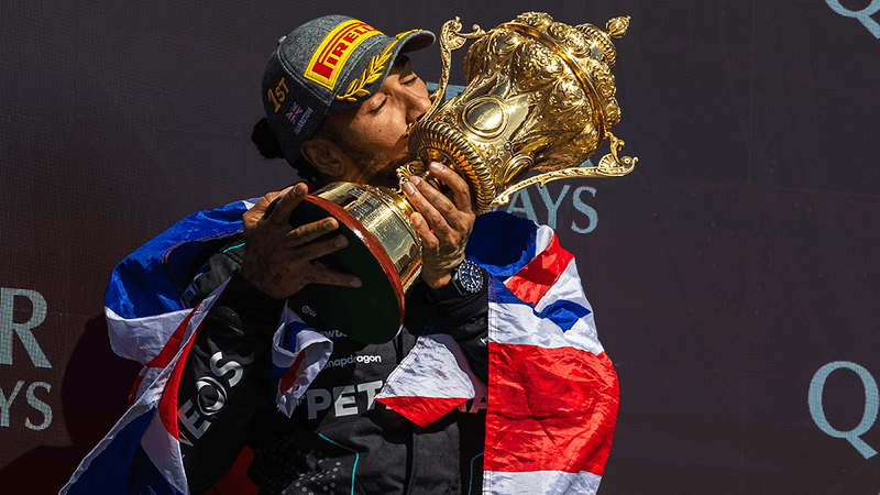 Lewis Hamilton holding a trophy.