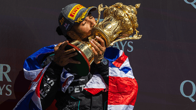 Lewis Hamilton holding a trophy.
