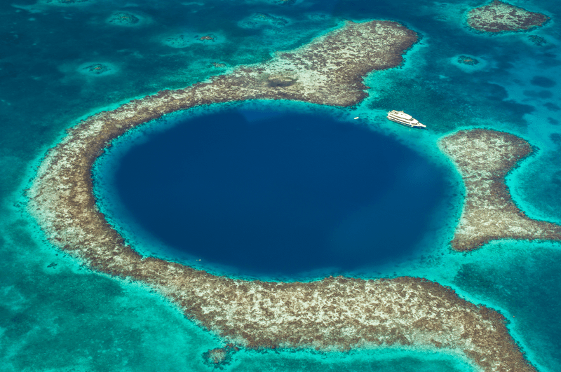 A boat near the Great Blue Hole, a marine sink hole in the reefs of Belize, Caribbean Sea