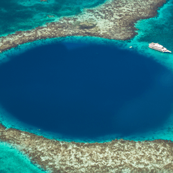 A boat near the Great Blue Hole, a marine sink hole in the reefs of Belize, Caribbean Sea