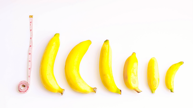Six bananas next to a measuring tape