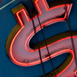 A neon light in the shape of an American dollar sign $$$$.