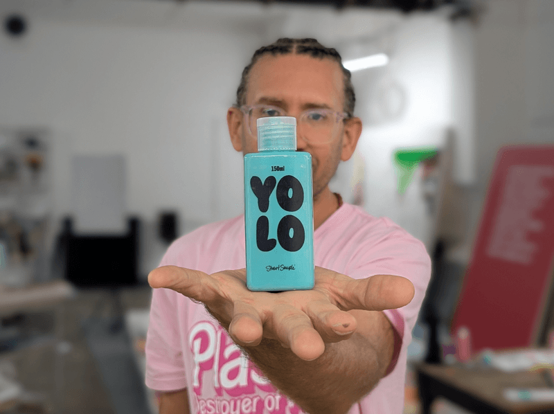 Artist Stuart Semple holds a bottle of YOLO paint inspired by a new color created in a new study