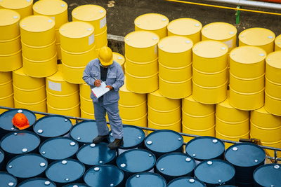Male worker inspection record drum oil stock barrels yellow vertical or chemical for transportation truck male in the industry.