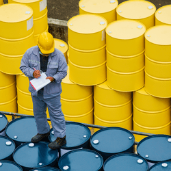 Male worker inspection record drum oil stock barrels yellow vertical or chemical for transportation truck male in the industry.