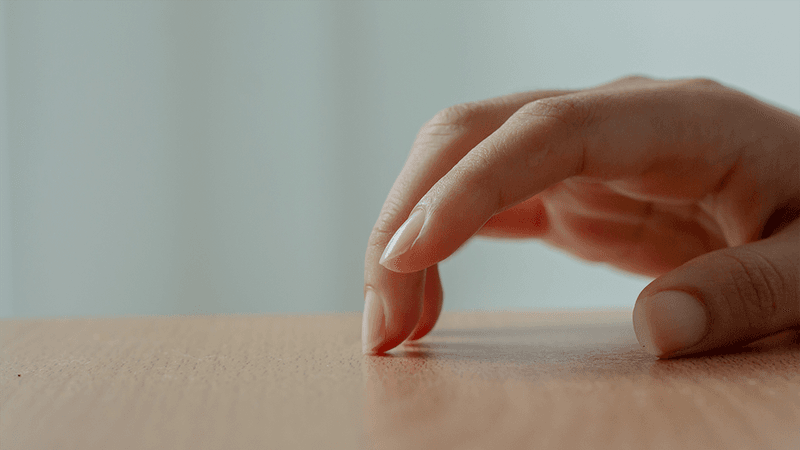 Fingers tapping on a table.